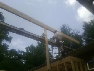 Carpenter setting a ridge beam over a new addition frame — Ice Dam Removal by Roofing Brothers in Murrysville