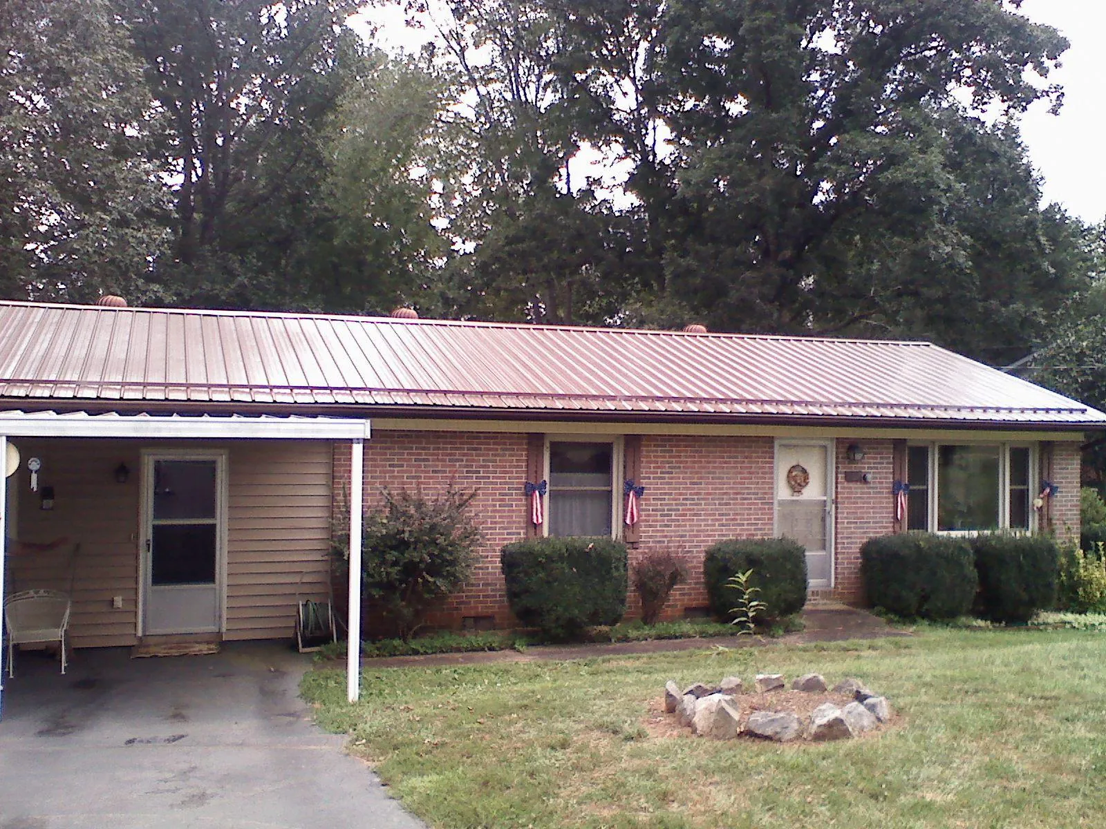 Bronze metal roof and carport on a brick ranch home — Roof Repair work by our crew in Murrysville